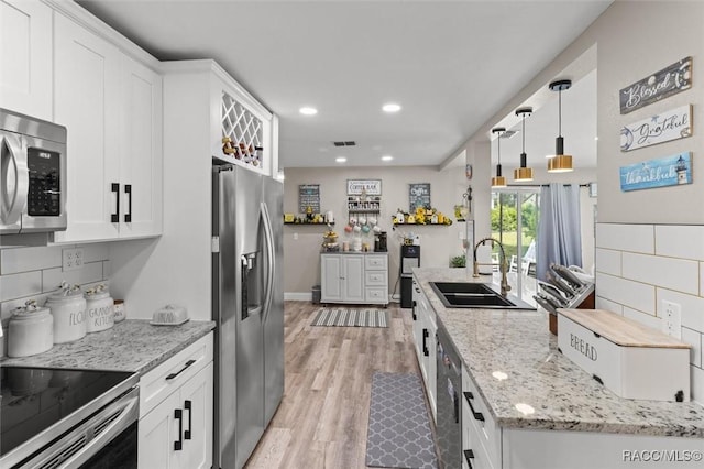 2 William Tell Ln, Beverly Hills, FL 34465 - kitchen featuring appliances with stainless steel finishes, light wood finished floors, white cabinets, tasteful backsplash, and recessed lighting