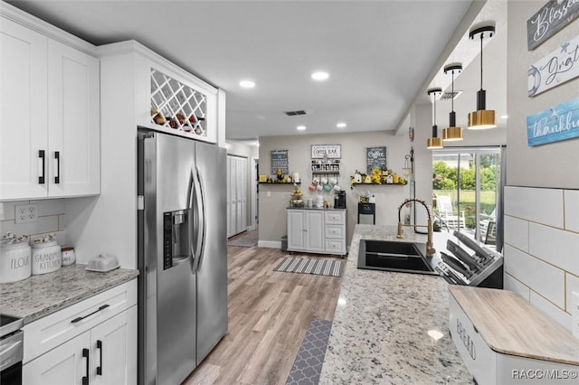 2 William Tell Ln, Beverly Hills, FL 34465 - kitchen with stainless steel fridge, recessed lighting, white cabinets, light wood-type flooring, and light stone countertops