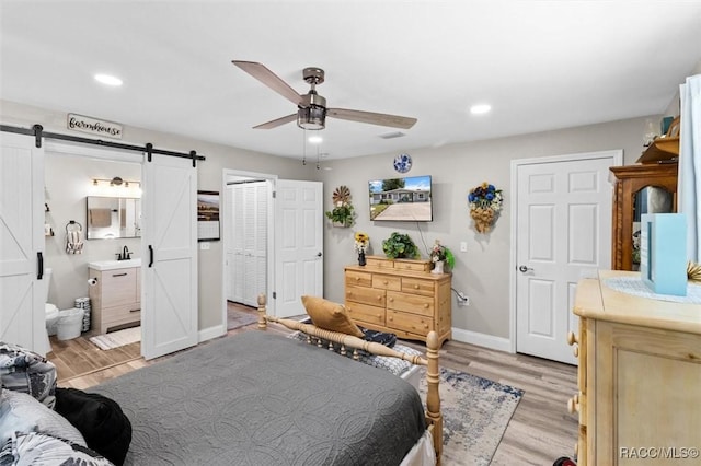 2 William Tell Ln, Beverly Hills, FL 34465 - bedroom featuring a barn door, light wood-style floors, recessed lighting, a ceiling fan, and ensuite bathroom