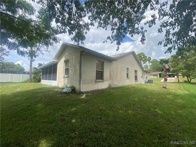 view of property exterior with a sunroom and a yard