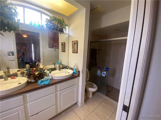 bathroom with tile patterned floors, vanity, toilet, and walk in shower