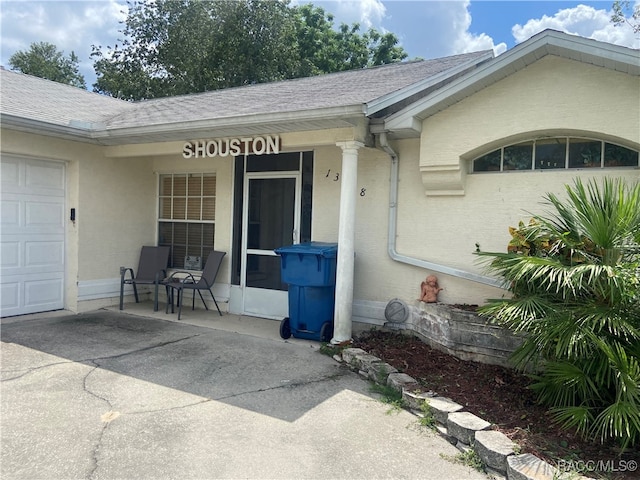 view of exterior entry with covered porch and a garage