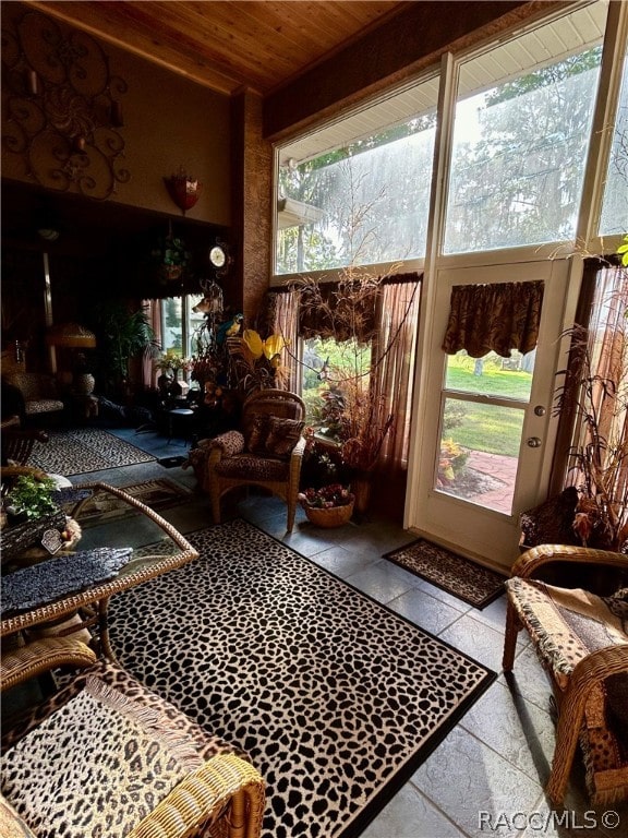 sunroom / solarium with beamed ceiling, plenty of natural light, and wooden ceiling