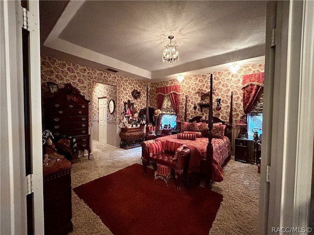 bedroom with carpet floors, a textured ceiling, a tray ceiling, and an inviting chandelier