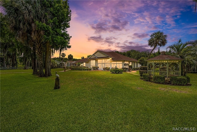 yard at dusk with a gazebo