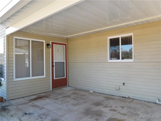 view of exterior entry featuring a patio