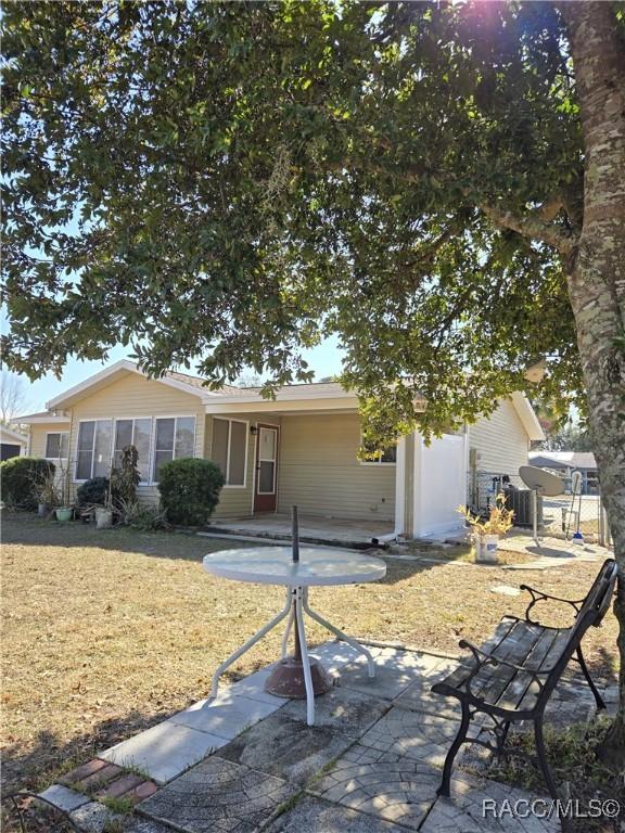 rear view of property with a patio and a lawn