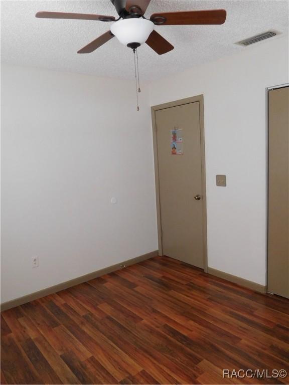 unfurnished room with dark hardwood / wood-style floors and a textured ceiling