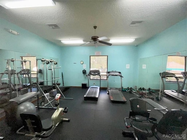 workout area with ceiling fan and a textured ceiling