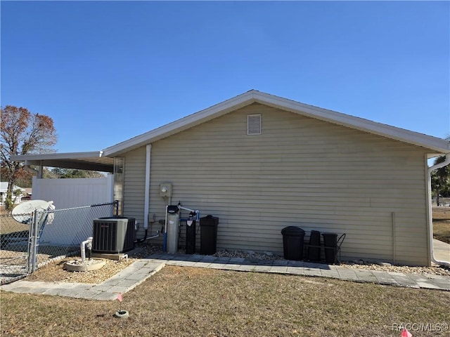 view of side of home featuring a yard and central AC unit