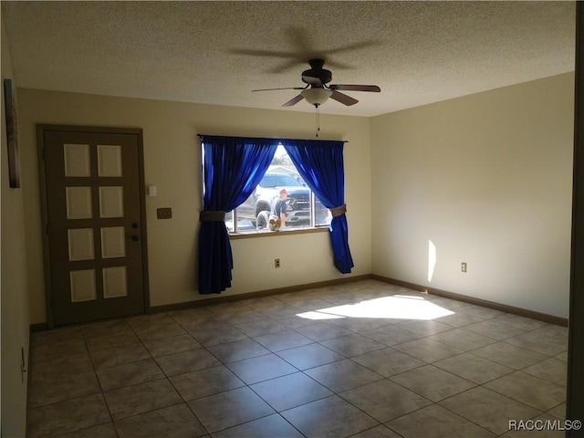 unfurnished room featuring a textured ceiling, ceiling fan, and light tile patterned flooring