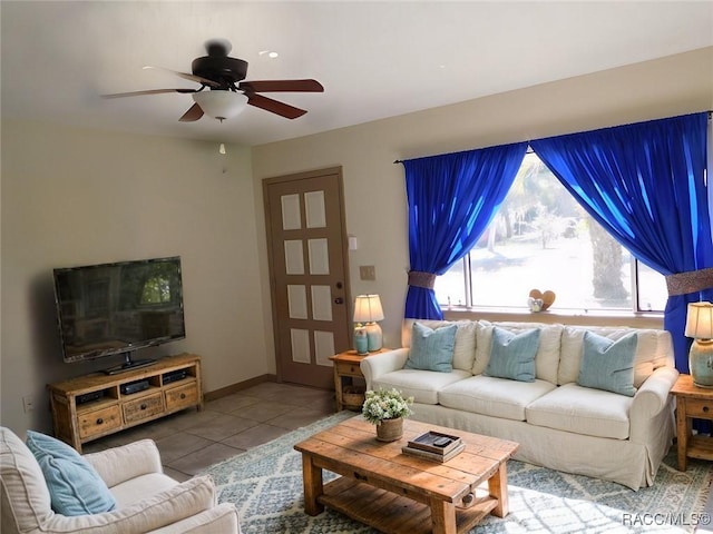 tiled living area featuring baseboards and ceiling fan