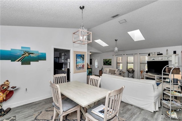 9844 SW 198th Cir, Dunnellon, FL 34432 - dining space featuring lofted ceiling with skylight, wood finished floors, a textured ceiling, and visible vents