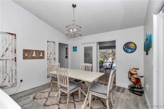 9844 SW 198th Cir, Dunnellon, FL 34432 - dining room featuring baseboards, wood finished floors, a textured ceiling, and a chandelier