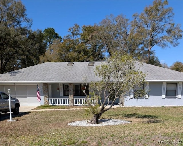 9844 SW 198th Cir, Dunnellon, FL 34432 - view of front of home with stone siding, a shingled roof, covered porch, an attached garage, and a front yard