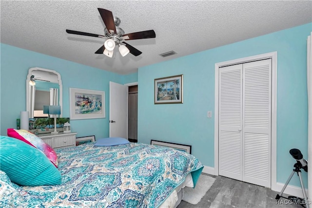 9844 SW 198th Cir, Dunnellon, FL 34432 - bedroom with wood finished floors, visible vents, a ceiling fan, a closet, and a textured ceiling