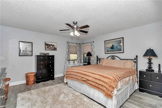 9844 SW 198th Cir, Dunnellon, FL 34432 - bedroom with wood finished floors, a textured ceiling, a ceiling fan, and baseboards