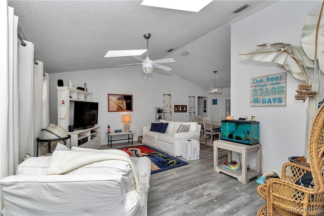 9844 SW 198th Cir, Dunnellon, FL 34432 - living area with a textured ceiling, visible vents, vaulted ceiling with skylight, wood finished floors, and ceiling fan