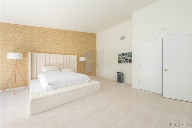 carpeted bedroom featuring high vaulted ceiling