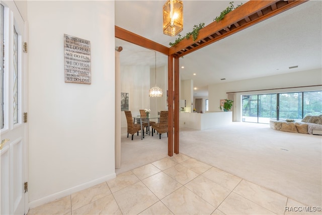 entrance foyer with beamed ceiling, light carpet, and a notable chandelier