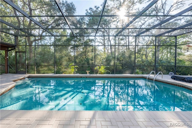 view of pool with a patio and glass enclosure