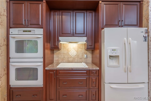 kitchen with tasteful backsplash, white appliances, and light stone countertops