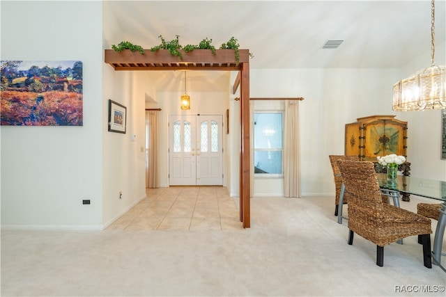 carpeted foyer featuring an inviting chandelier