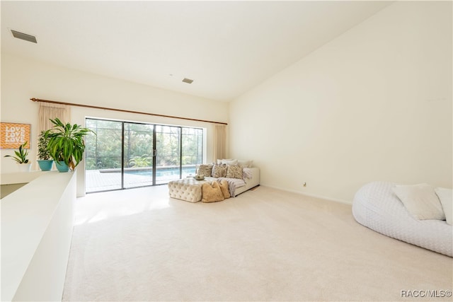 sitting room featuring high vaulted ceiling and carpet