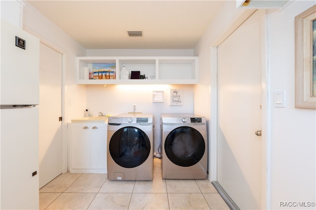 laundry area with sink, washer and dryer, and light tile patterned flooring