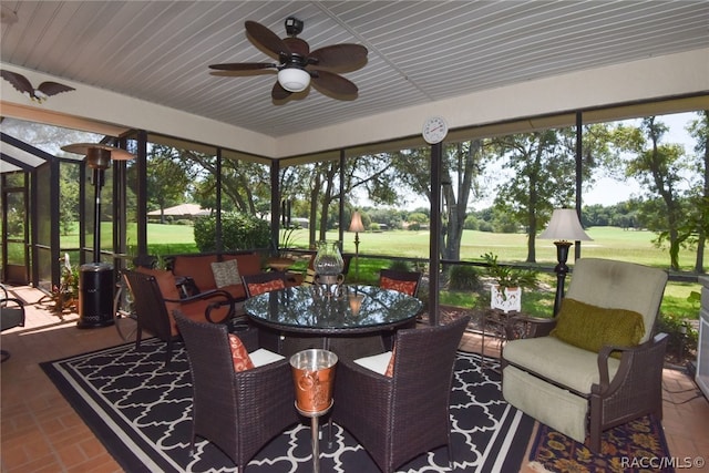 sunroom featuring ceiling fan and plenty of natural light