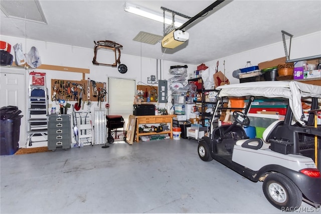 garage with a workshop area, electric panel, and a garage door opener