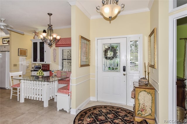 entrance foyer with ceiling fan with notable chandelier, light tile patterned flooring, and crown molding