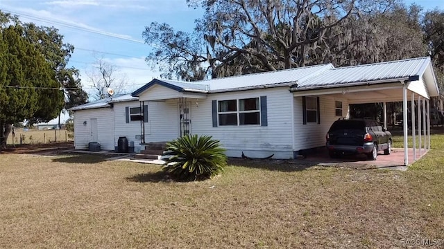 view of front of home with a front lawn and a carport