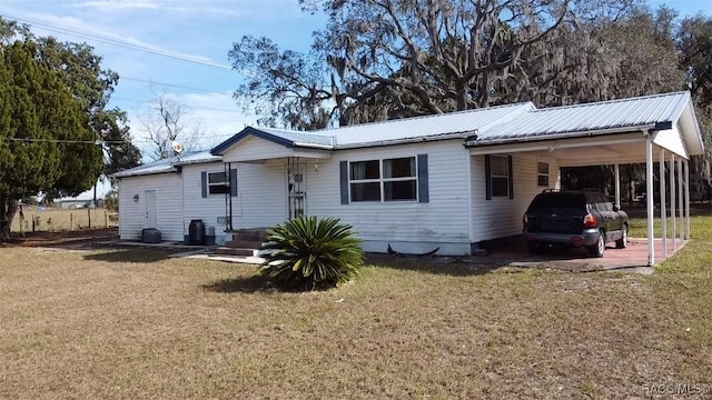 view of front of home with a carport and a front yard