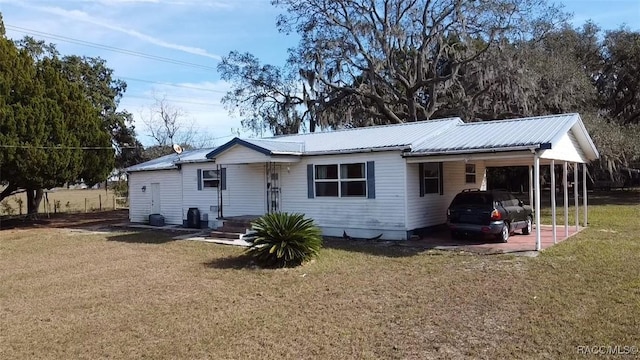 ranch-style home featuring a carport and a front yard