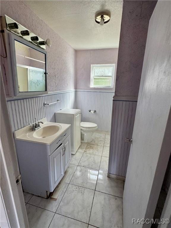 bathroom featuring vanity, toilet, and a textured ceiling