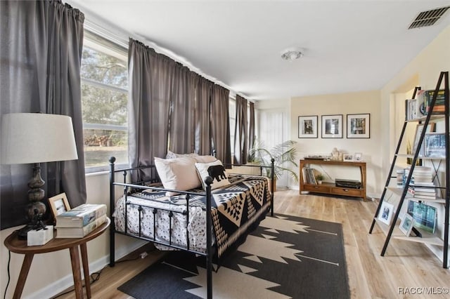 bedroom with baseboards, visible vents, and light wood-style floors