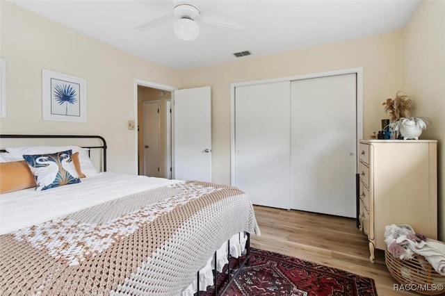 bedroom with a ceiling fan, a closet, visible vents, and wood finished floors