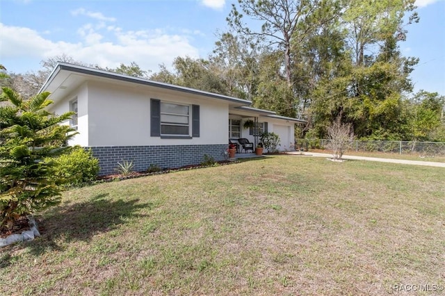 single story home with brick siding, concrete driveway, fence, a garage, and a front lawn