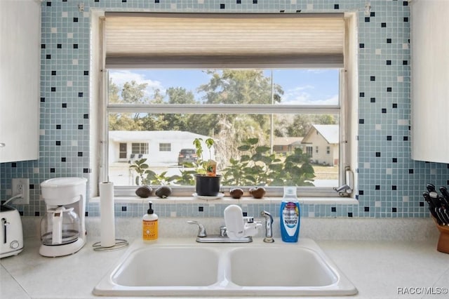 kitchen with light countertops, a sink, and tile walls