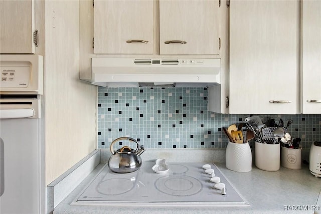 kitchen with white appliances, tasteful backsplash, light countertops, under cabinet range hood, and light brown cabinets