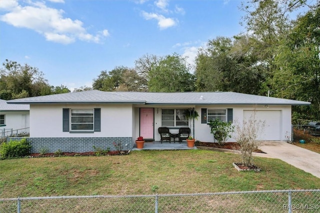 single story home with concrete driveway, stucco siding, an attached garage, a front lawn, and brick siding