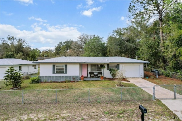 ranch-style house with a fenced front yard, brick siding, a garage, driveway, and a front lawn