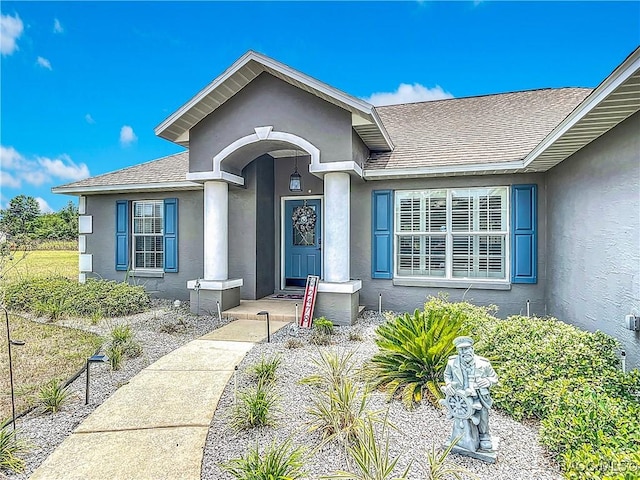 2478 W Angola Dr, Beverly Hills, FL 34465 - doorway to property featuring stucco siding and a shingled roof