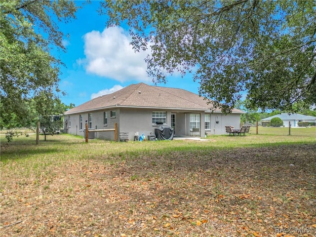 2478 W Angola Dr, Beverly Hills, FL 34465 - rear view of house with stucco siding, a yard, and a patio