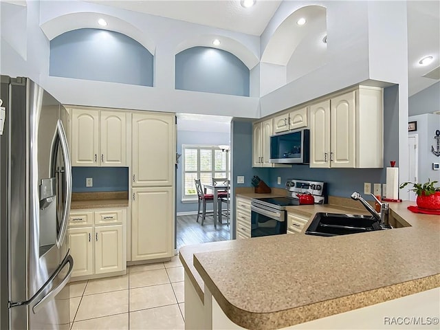 2478 W Angola Dr, Beverly Hills, FL 34465 - kitchen featuring appliances with stainless steel finishes, light tile patterned floors, a peninsula, recessed lighting, and light countertops
