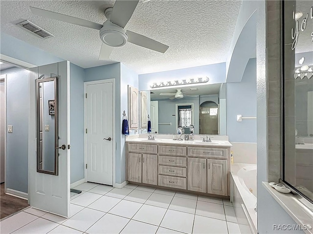 2478 W Angola Dr, Beverly Hills, FL 34465 - full bath with ceiling fan, double vanity, a bath, tile patterned flooring, and a textured ceiling