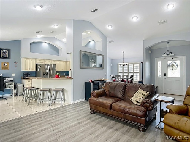 2478 W Angola Dr, Beverly Hills, FL 34465 - living area featuring a chandelier, light wood-type flooring, arched walkways, and high vaulted ceiling