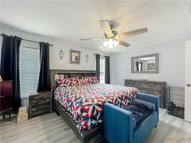 2478 W Angola Dr, Beverly Hills, FL 34465 - bedroom with light wood-type flooring, a textured ceiling, and a ceiling fan
