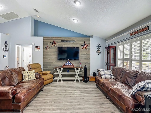 2478 W Angola Dr, Beverly Hills, FL 34465 - living room featuring vaulted ceiling, light wood-type flooring, and a textured ceiling